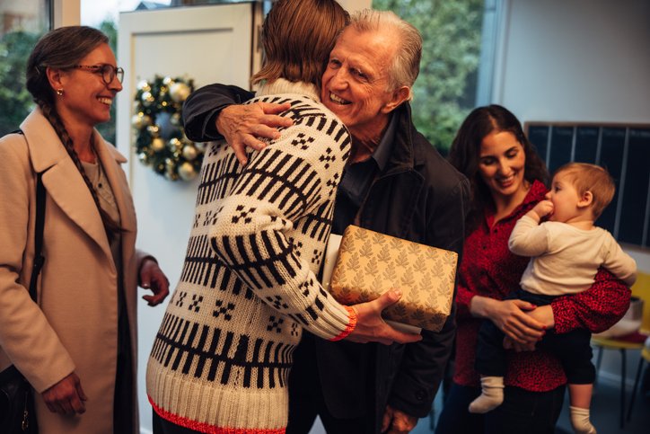 Family members embracing and exchanging a gift during a holiday visit