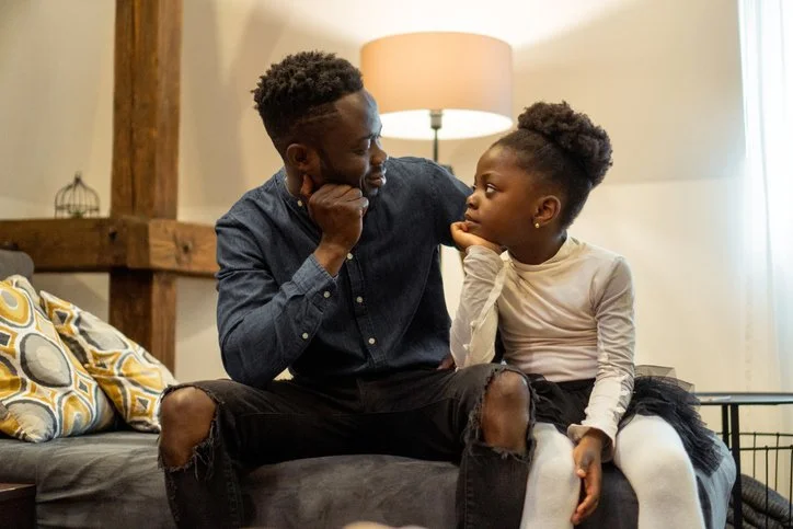 Parent and child having a conversation together on the couch at home